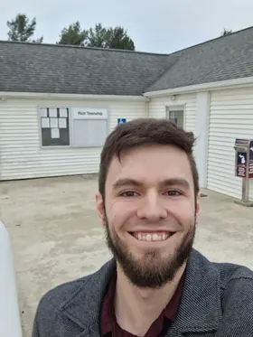Brendan Johnson standing in front of an aerial map of the district, knowing the land he wants to represent